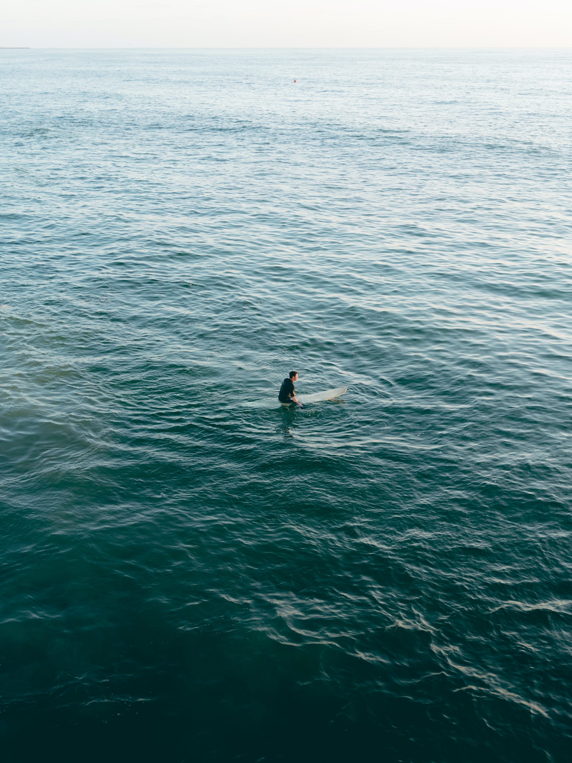 Surfer sitting on a surf board in calm water
